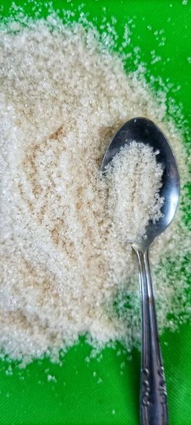 a silver teaspoon with a pile of white sugar on top - Foto, immagini