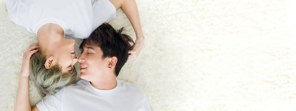 On top of Happy Asian homosexual men or gay couples are lying on the white wool carpet, Both of them are in the mood of love and attachment. Concept of LGBTQ pride. - Photo, image