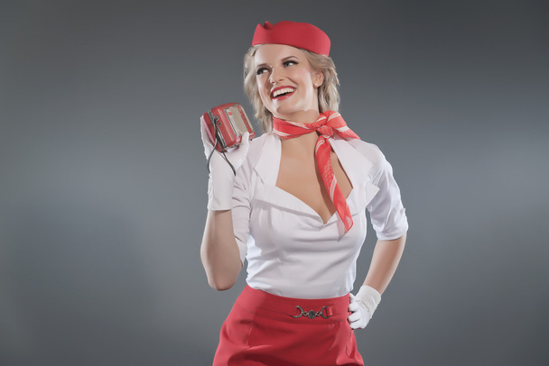 Sonriente retro rubia azafata con falda roja y gorra con w
 - Foto, Imagen