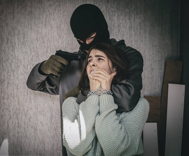 Terroristi naispanttivangin kanssa ulkona - Valokuva, kuva