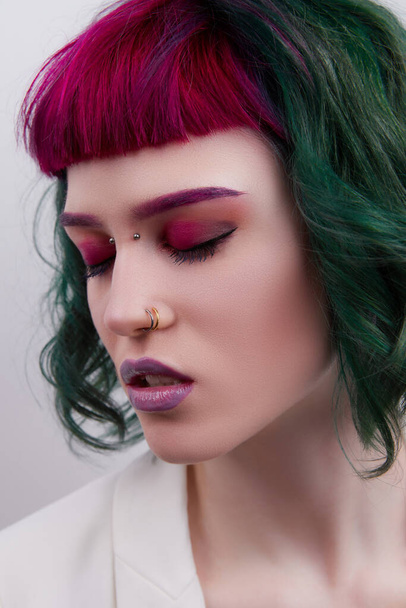Beautiful woman with purple green professional colored hair. Bright eyes and lips makeup - 写真・画像