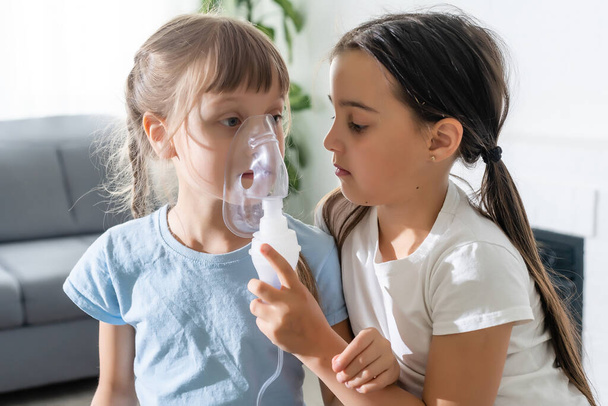 Niña haciendo inhalación con nebulizador en casa. inhalador de asma infantil inhalación nebulizador vapor concepto de tos enferma. - Foto, imagen
