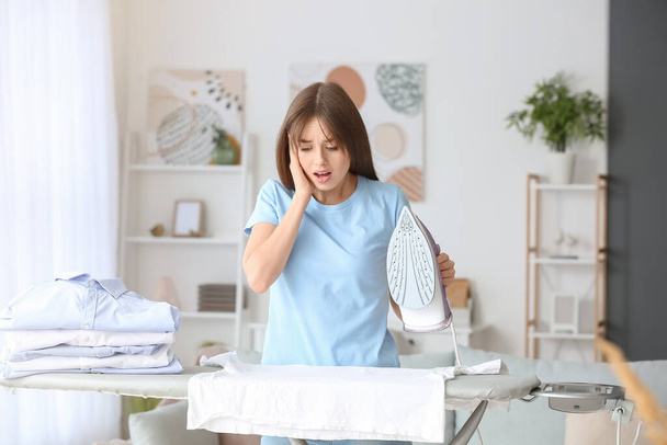 Scioccato giovane donna stiratura lavanderia a casa - Foto, immagini