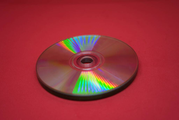 Um cd rom no fundo vermelho. Espaço de cópia de banner. Conceito de tecnologia - Foto, Imagem