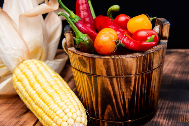 Corncob with chili peppers and tomatoes fresh vegetables natural food in wooden bucket, organic - Foto, Imagem