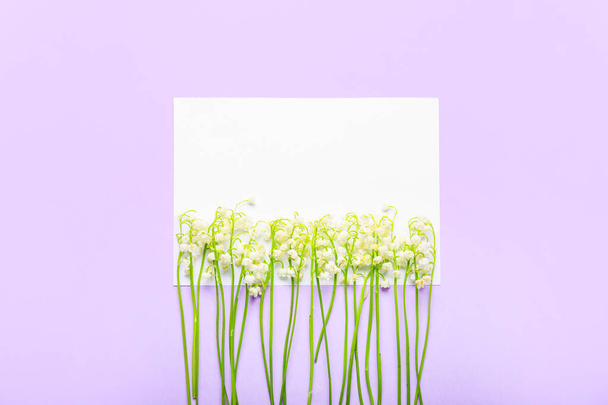 Λευκή κάρτα και όμορφα λουλούδια κρίνος της κοιλάδας στο φόντο χρώμα - Φωτογραφία, εικόνα