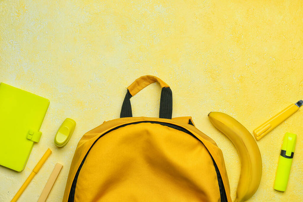 School backpack and stationery on color background - Foto, Bild