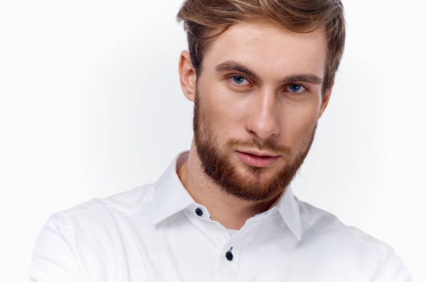 blond man with a thick beard and mustache in a white shirt on a light background - Photo, Image