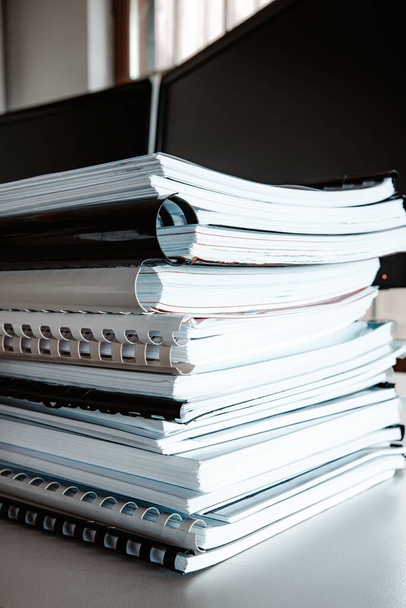 Stack of reports lies on a desk ready for review - Photo, Image