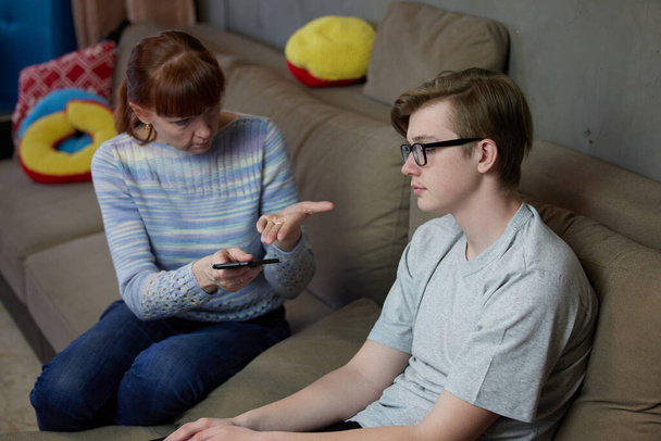 Mother son teenager talking at home family relationship on the couch. High resolution photos - Foto, imagen
