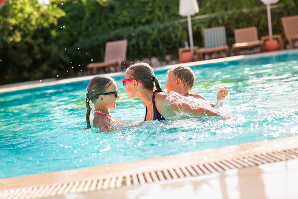 Happy kids having fun at the pool at the resort - 写真・画像