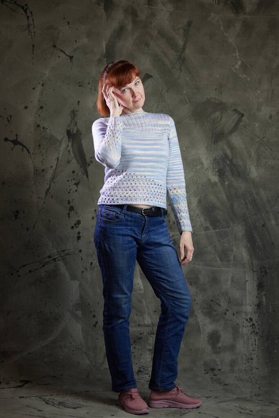 Portrait of cute Caucasian woman posing in full growth in jeans in studio on gray background. High resolution photos - Φωτογραφία, εικόνα