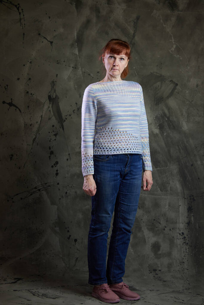 Portrait de mignonne femme caucasienne posant en pleine croissance en jeans en studio sur fond gris. Photos haute résolution - Photo, image