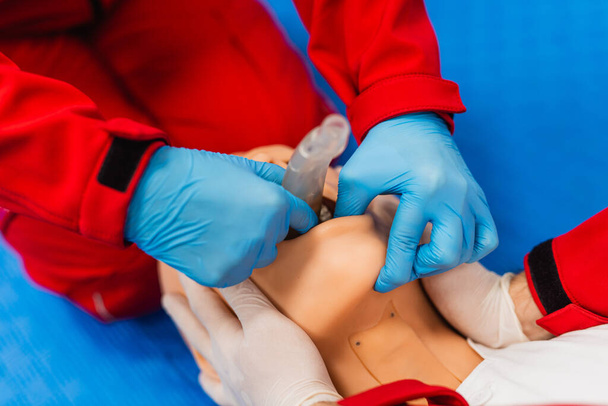 Φοιτητές Νοσηλευτικής μαθαίνουν πώς να σώσουν τους ασθενείς σε περίπτωση έκτακτης ανάγκης. Εκπαίδευση CPR με κούκλα CPR. Πρώτες βοήθειες από κοντά - Φωτογραφία, εικόνα