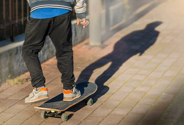 benen op skateboard close-up op de straat - Foto, afbeelding