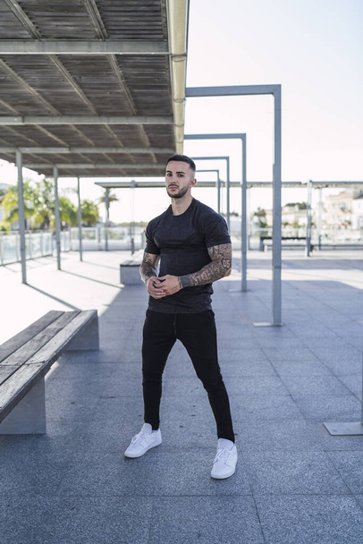 A young man with tattoos in cool casual style posing outdoors - 写真・画像