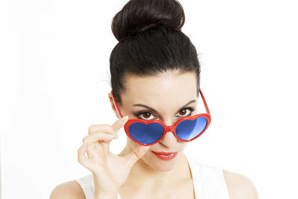 Portrait of a beautiful woman in blue with heart shaped glasses - Photo, Image