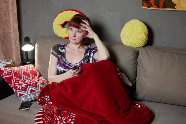 Portrait of caucasian adult woman sitting on sofa resting at home. High resolution photos - 写真・画像