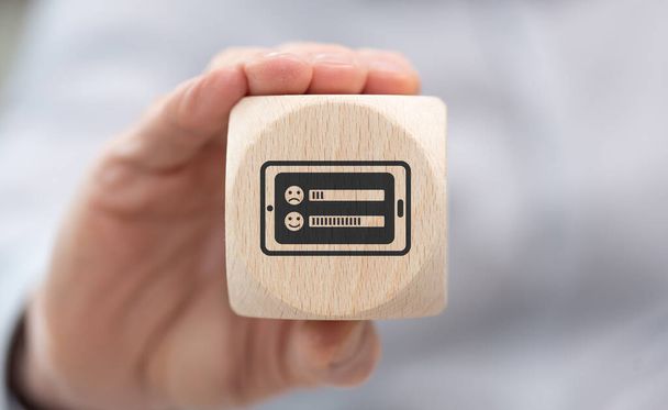 Hand holding a wooden cube with symbol of online survey concept - Photo, Image