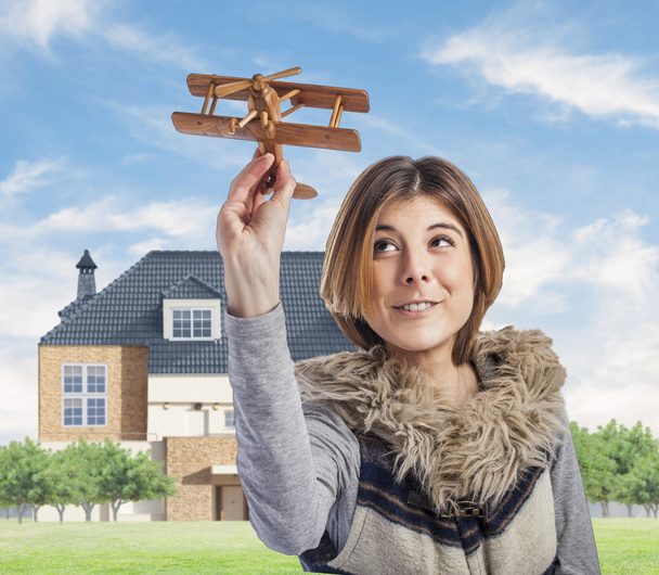 vrouw spelen met houten vliegtuig - Foto, afbeelding