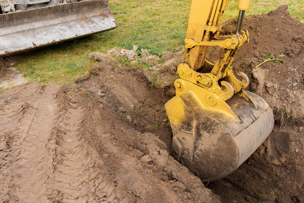 Bir kova kazıcı ve toprak yığını inşaat alanında bir çukur kazıyor. Sanayi işi. - Fotoğraf, Görsel
