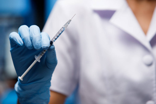 Enfermera presente Vacuna Covid-19 en jeringa de insulina para una dosis. Vacunación lista para curar y detener el coronavirus pandémico. Conceptos médicos y de salud - Foto, Imagen