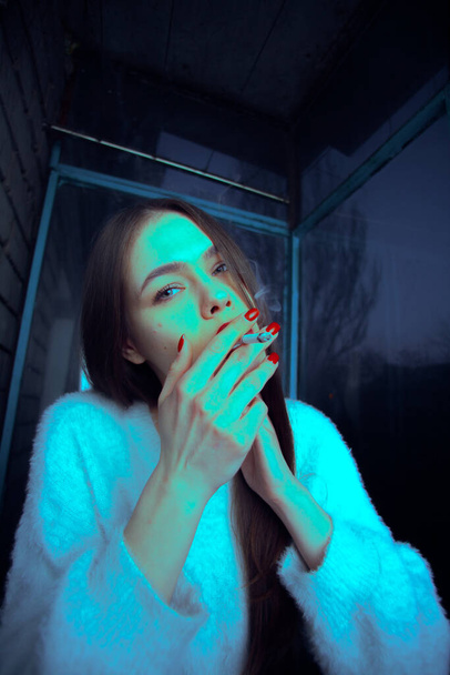 Young beautiful girl smokes a cigarette close up portrait. - Fotografie, Obrázek