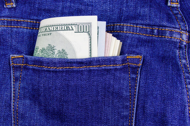 Billetes en dólares estadounidenses en el bolsillo de los vaqueros azules - Foto, imagen
