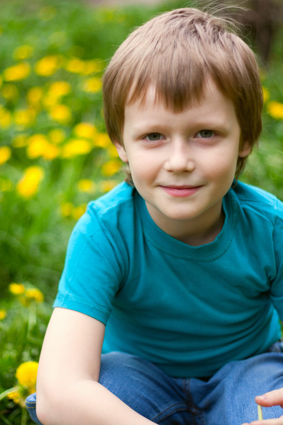 The boy in dandelions field. - Фото, зображення