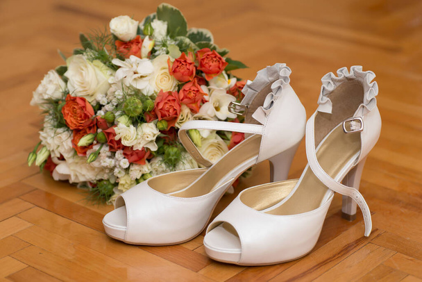 sposa bianco scarpe tacchi alti vicino al bouquet di nozze - Foto, immagini