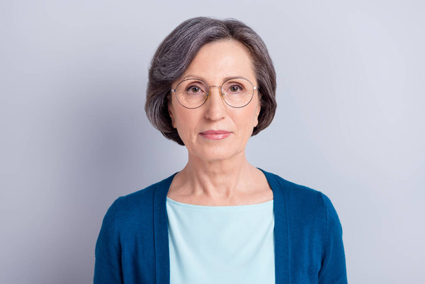 Portrait of attractive content intellectual gray haired woman wearing specs isolated over grey pastel color background - Fotoğraf, Görsel
