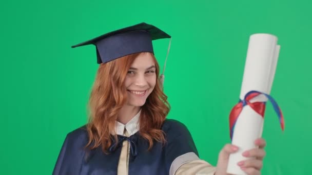 απόφοιτος με ακαδημαϊκά φιλιά φόρεμα και δίπλωμα στα χέρια και χαίρεται στην αποφοίτηση, προ-κλεισμένα πλάνα - Πλάνα, βίντεο