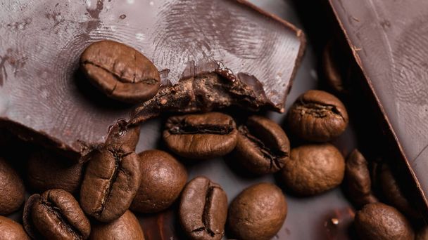 coffee beans close-up and chocolate. Dark chocolate bar. Natural background of cinnamon color. - Φωτογραφία, εικόνα