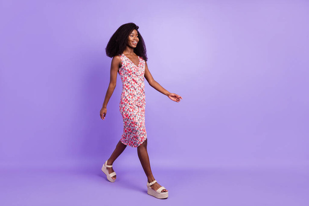 Full length body size side profile photo of smiling girl looking copyspace walking in dress isolated pastel purple color background - Foto, imagen