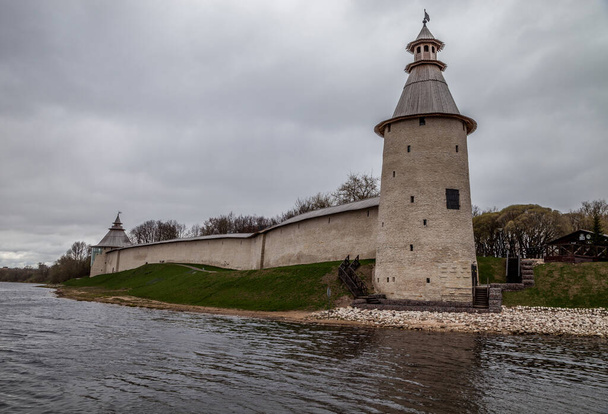 Ancient fortress on the river Bank. Pskov Kremlin. The Pskova River. The Great River. Cloudy spring day. Ancient Russian city. Pskov. - Zdjęcie, obraz