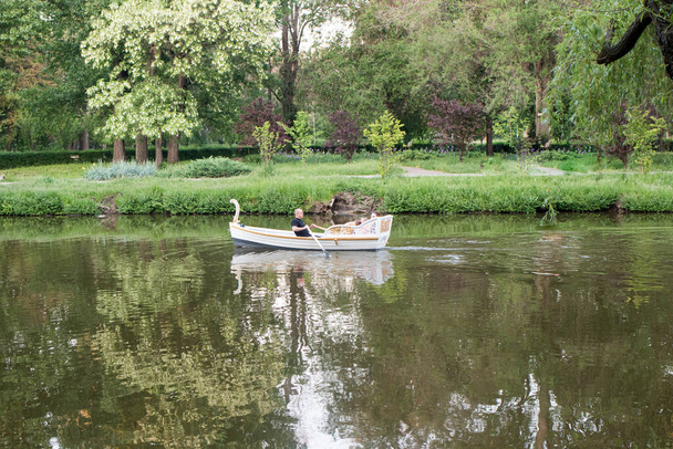 26 травня 2021 року Запоріжжя, Україна. Човен плаває на прекрасному озері в парку серед дерев влітку. Похід з метушливого міста. - Фото, зображення