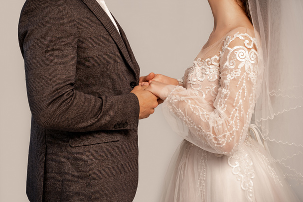 partial view of newlyweds holding hands isolated on grey - Photo, Image