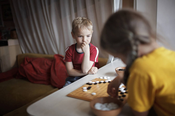 Αδέλφια διασκεδάστε μαζί παίζοντας σκάκι πάει στο σπίτι, παραδοσιακό κινέζικο επιτραπέζιο παιχνίδι, ψηφιακή αποτοξίνωση - Φωτογραφία, εικόνα