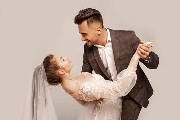 elegant couple of newlyweds dancing isolated on grey with lilac shade - Fotografie, Obrázek