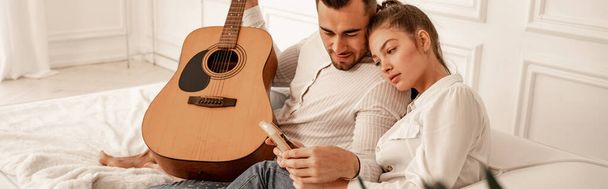 man with acoustic guitar looking at mbira in hands of girlfriend, banner - Φωτογραφία, εικόνα