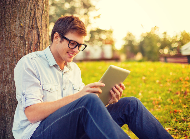 smiling male student in eyeglasses with tablet pc - Foto, Imagen