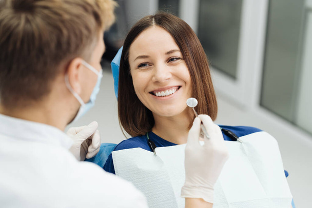 Zahnarzt diskutiert mit Patient Behandlungsplan - Foto, Bild