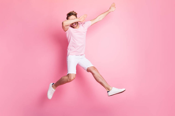 Full body portrait of cheerful excited man arms dabbing toothy smile jumping isolate don pink color background - Fotografie, Obrázek