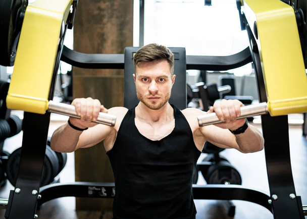 Muscular handsome man working out in the gym. Bodybuilding male hard training. - 写真・画像