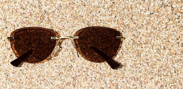 Tinted sunglasses lie on the sand on the beach - Valokuva, kuva