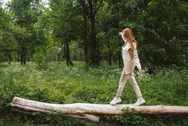 Stress and resilience. Spend Time in Nature to Reduce Stress and Anxiety. Nature break relieves stress. Young woman in suit enjoying nature and walking in green summer park - Фото, зображення