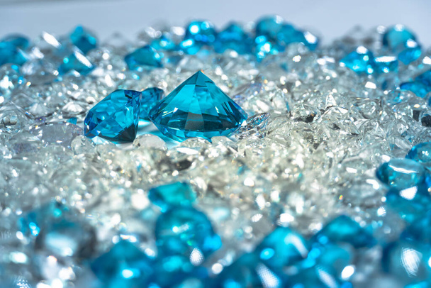 Un grupo de diamantes azul aguamarina dispuestos en medio de diamantes blancos sobre un fondo blanco - Foto, imagen