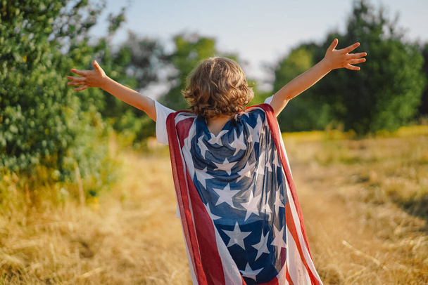 Rapaz patriota feliz correndo no campo com bandeira americana. EUA celebram 4 de julho - Foto, Imagem
