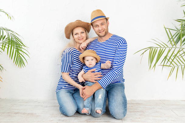 ευτυχισμένη οικογένεια μητέρα, ο πατέρας και το μωρό σε μια ναυτική εικόνα σε γιλέκα και καπέλα, η έννοια του ταξιδιού και αναψυχής - Φωτογραφία, εικόνα