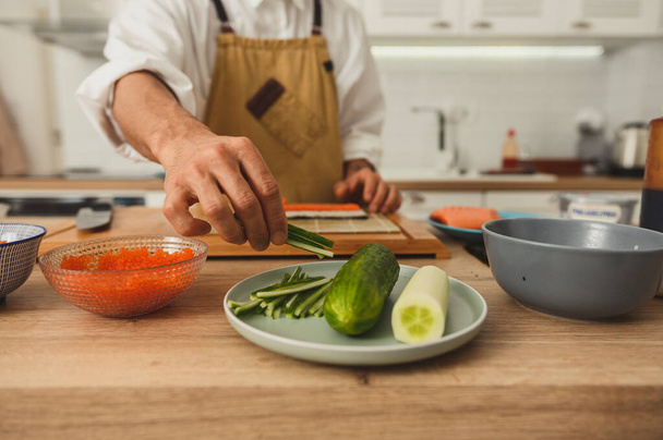 Κοντινό πλάνο σεφ χέρια κάνοντας ρολά στην κουζίνα. Επίλεκτη εστίαση εμπρόσθιας προβολής - Φωτογραφία, εικόνα